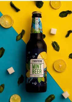 a bottle of mint and lemon beer next to some ice cubes on a yellow and blue background