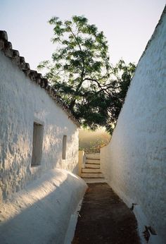 an alley way between two buildings with steps leading up to the top and bottom one