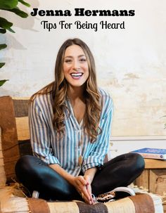 a smiling woman sitting on top of a chair in front of a potted plant