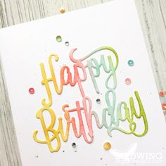 a birthday card with the words happy birthday written in rainbow colors on it and confetti sprinkles