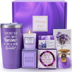 a purple gift box filled with candles, cards, and other personal care items for someone special