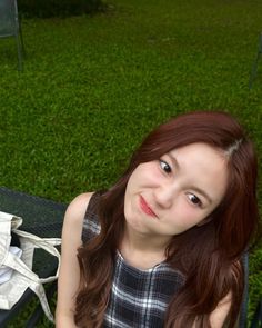 a young woman sitting on top of a green bench