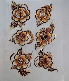 some brown and white flowers on a sheet of paper with gold foiling around them