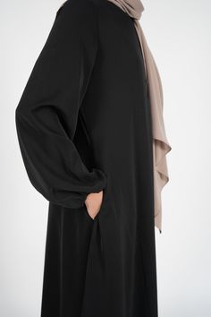 Description: Modest U-neckline. Front chest invisible zipper. Very light polyester fabric Poet sleeves with elastic band Pockets This Simple Abaya is with invisible front zipper making the garment display of seamless finish. Abaya had a nice light fabric flow and includes pockets. Its the perfect choice for on the go that can be styled with any accessories or can be layered on. Colors: Available in Black, Navy, Blue Features: Modest U-Neckline: The modest U-neckline complements the abaya's overa Simple Burkha Designs, Black Abaya Designs Simple, Simple Abaya Designs, Burkha Designs, Simple Abaya, Dresses Hijab, Black Abaya Designs, Abaya Black, Athletic Accessories