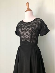 "* 1950s black cocktail dress * full pleated taffeta skirt * pointed inverted basque waist * sheer double layer lace bodice * short sleeves with taffeta cuffs and bows * scoop neck * low v-back * back metal zipper with series of hooks and eyes ✂ Measurements Bust: 36\"-37\" (dolman sleeves) Waist: 23\"-23.5\" (maybe a very snug 24\") Hips: free Shoulder to waist: 15\" Waist to hem: 26.5\" Length: 41.5\" Fits like: extra small Condition: Good. Some small breaks in the lace on the bodice - these w Vintage Fit And Flare Dress For Party, Vintage Fit And Flare Party Dress, Party Dress With Pleated Skirt And Fitted Bodice, Vintage Party Dresses With Pleated Waist, Pleated Vintage Dress For Party, Vintage Pleated Dress For Party, 1950s Style Short Sleeve Party Dresses, Vintage Pleated Party Dresses, 1950s Style Fit And Flare Party Dress