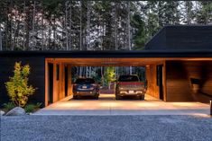 two cars are parked in front of a garage with lights on the roof and doors open