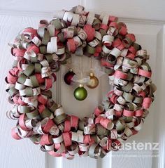 a wreath hanging on the front door decorated with ribbon and christmas ornament ornaments