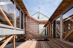 a wooden deck with stairs leading up to the top floor and windows on both sides