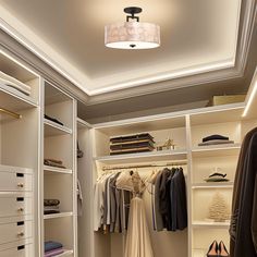 a white closet with clothes and shoes hanging on the shelves, lighting from above it