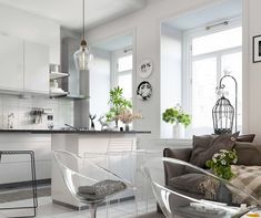 a living room filled with furniture next to a kitchen and dining room table in front of a window