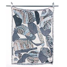 a blue and white tapestry hanging from a metal hook on a clothes line with an abstract design