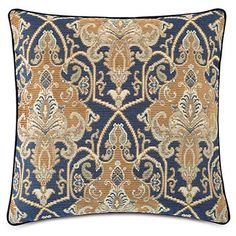 a blue and gold pillow with an ornate design on the front, along with a white background