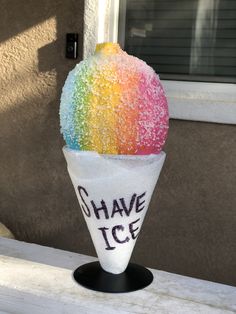 an ice cream cone with rainbow colored sprinkles on it that says shave ice