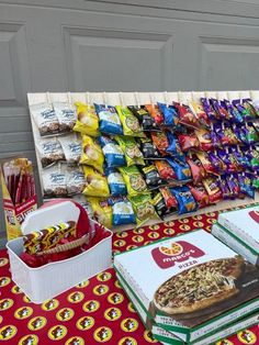 a table with pizza, chips and snacks on it