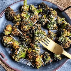 broccoli florets on a blue plate with a gold fork in it