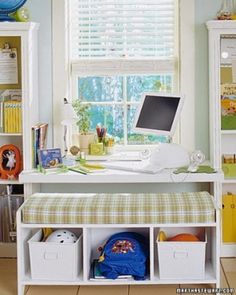 there is a computer on the desk in this room with many bookshelves and toys