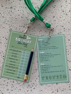 a green birthday card with a pen attached to it and a lanyard around the neck