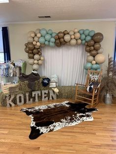 a living room filled with furniture and balloons in the shape of animals on hay bales