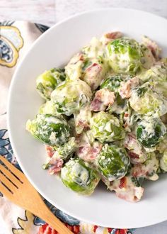 a white bowl filled with brussel sprouts and bacon