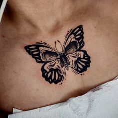 a black and white butterfly tattoo on the chest