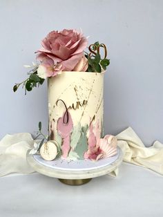 a cake decorated with pink flowers and leaves