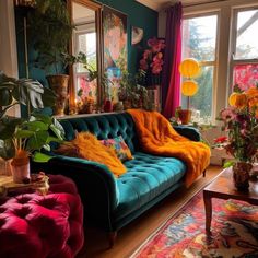 a living room filled with colorful furniture and lots of plants in the window sill