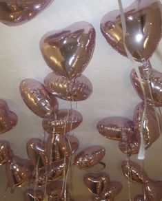 many metallic heart shaped balloons hanging from the ceiling