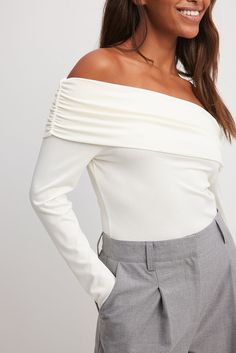 This long sleeve top features a stretchy material and a folded off shoulder design with gathering.