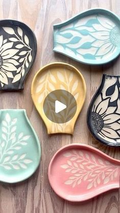 six ceramic dishes with designs on them sitting on a wooden table next to each other