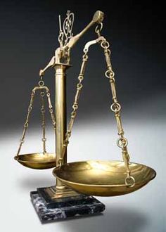 a golden balance scale sitting on top of a marble block in front of a gray background