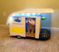 a white dog standing in the back of a toy food truck with its lights on