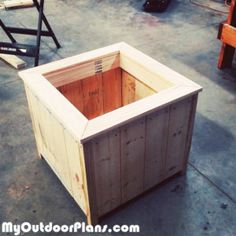 a wooden box sitting on top of a cement floor