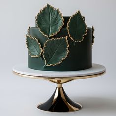 a green and gold cake with leaves on top