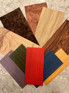 several different types of wood are arranged on the floor in various colors and shapes, including red, yellow, green, blue, brown