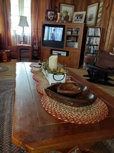 a living room filled with furniture and a flat screen tv on top of a wooden table