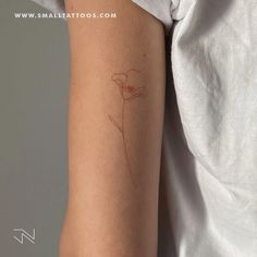 a woman's arm with a tattoo on it that has a flower drawn on it