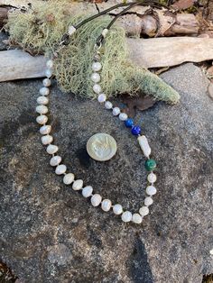 Fresh water pearls, two lapis beads, a baroque pearl, and a turquoise bead all hand knotted. The strand is wire wrapped with silver plated copper wires onto a black leather cord. The necklace is 25.5" long. HANDMADE WITH LOVE.  Each color, type of stone or material and design are thoughtfully put together and personally hand strung by me. Every piece of jewelry I make is unique and one of a kind, so you'll have something no one else has! Please know that in the stills and videos you see I try hard to show the true colors and details of my pieces using natural light. However, some outdoor lighting and even computerized images can vary, making some items appear slightly different online than they actually are. When packaged, your piece will be gift boxed with my business card, and will be se Blue Baroque Pearl Jewelry With Pearl Drop, Blue Baroque Pearl Necklace With Pearl Charm, Handmade Blue Baroque Pearl Necklace, Handmade Blue Baroque Pearl Necklaces, Blue Bohemian Jewelry With Pearl Charm, Bohemian Blue Jewelry With Pearl Charm, Adjustable Single Strand Baroque Pearl Beaded Necklaces, Adjustable Baroque Pearl Beaded Necklaces, Fresh Water Pearls