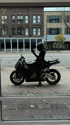 a motorcycle parked in front of a building with a person sitting on the back of it