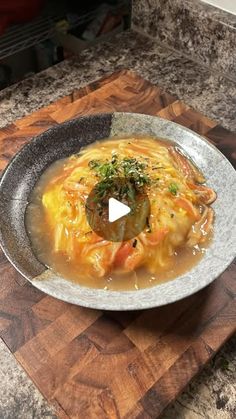 a bowl filled with soup on top of a wooden cutting board