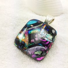 a glass pendant is sitting on some snow