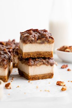 three pieces of dessert sitting on top of a table next to a glass of milk