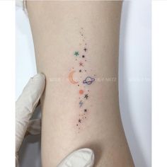 a woman's thigh with stars and planets on her left side, while she is wearing white gloves