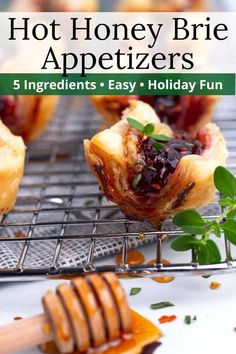 some food is sitting on a cooling rack with honey and green sprigs in it