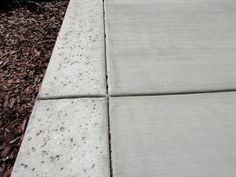 the sidewalk is made of cement and has little holes in it