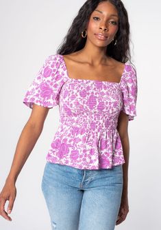 [Color: Ivory/Lilac] A model wearing a purple and white floral print bohemian peplum top with a slim fit smocked bodice and short flutter sleeves. Rose Flower Print, Sweet Talker, Bohemian Top, Gothic Shirts, Preppy Summer Outfits, Short Blouses, Tie Neck Tops, Bohemian Tops, Blouse Models