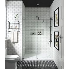 a bathroom with black and white tiles on the floor, shower stall, and toilet