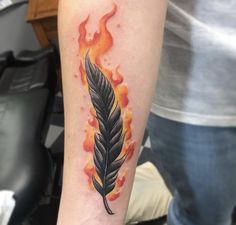 a tattoo with a feather and flames on it