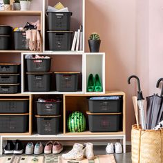 several black baskets and umbrellas on shelves in a room