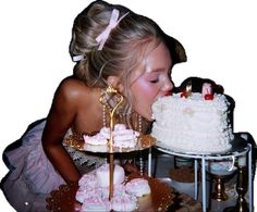 a woman kissing a cake on top of a table