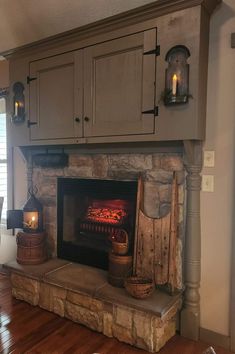 a fire place in the middle of a living room with wood flooring and cabinets